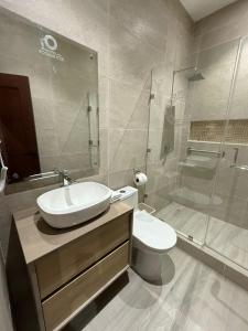 a bathroom with a sink and a toilet and a shower at Posada Itza Peten in Santa Elena +24 photos