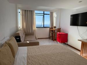 a hotel room with a bed and a large window at Vitória Marina Flats in Salvador