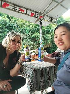 two women sitting at a table with cups of coffee at H'mong Village Homestay in Sapa