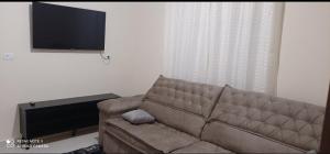 a living room with a couch and a flat screen tv at Recanto do Araguaia in Aragarças