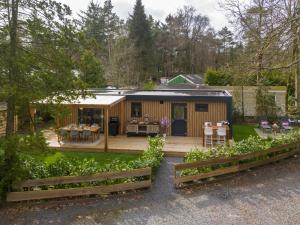a small cabin with a deck in a yard at Het Hertenpad in Hattemerbroek