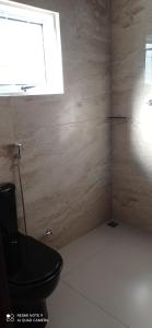 a bathroom with a black toilet and a window at Recanto do Araguaia in Aragarças +25 photos