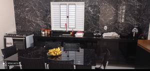 a kitchen with a table with a bowl of bananas on it at Recanto do Araguaia in Aragarças