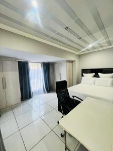 a hotel room with a bed and a desk and a chair at Modern Comfort, Easy Access Everywhere in Vanderbijlpark