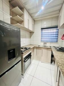 a kitchen with white cabinets and a stove top oven at Modern Comfort, Easy Access Everywhere in Vanderbijlpark +16 photos