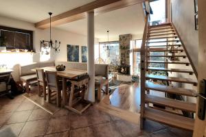 a dining room and kitchen with a table and a staircase at Villa Sofia - dovolenkový dom pre 8 osôb in Batizovce