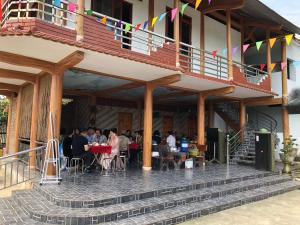 a group of people sitting at tables outside of a building at Trần Sơn Homestay in Tuyên Quang