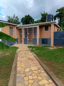 a house with a stone path in front of it at Linstead Riverview Retreat in Linstead