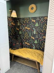 a bed in a room with a wall covered in wallpaper at Mountainside w Fireplace, Fire Pit, Deck, & WiFi in Smith Crossroads