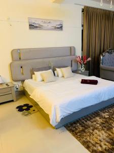 a bedroom with a large bed with white sheets at Celebirity garden 4 bhk -5 Bed Lulu and plassio mall gomti nagar in Lucknow