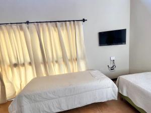 a bedroom with two beds and a window with curtains at Monoambiente PIPE in Bella Vista