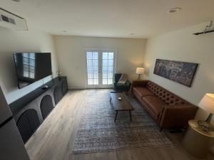 a living room with a couch and a flat screen tv at The Bourbon & Brass - Speakeasy-Inspired 2BDR in St. Charles