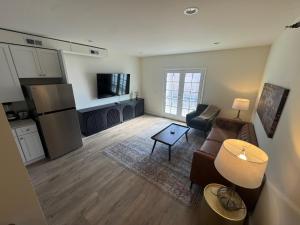 a living room with a couch and a kitchen at The Bourbon & Brass - Speakeasy-Inspired 2BDR in St. Charles