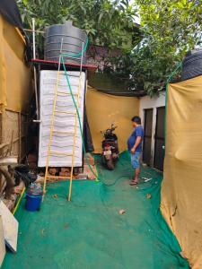 a man standing in a tent next to a motorcycle at Cookiewalla in Arambol