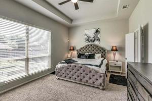 a bedroom with a bed with a ceiling fan and a window at Dei Puer in Glenn Heights