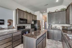 a large kitchen with wooden cabinets and granite counter tops at Dei Puer in Glenn Heights