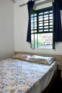 a bed in a room with a window at Casaraosete7 in Salvador