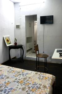 a room with a bed and a table and a chair at Casaraosete7 in Salvador