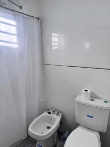 a white bathroom with a toilet and a sink at Mística colonial in Gualeguay +8 photos