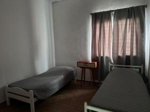 two beds in a small room with a window at Mística colonial in Gualeguay
