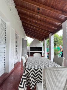 a table and chairs on a porch with a table and a piano at Mística colonial in Gualeguay