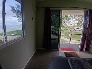 an open door to a room with a view of the ocean at Sunset Beach House in Kudat