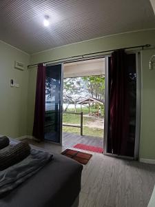 a bedroom with a sliding glass door to a patio at Sunset Beach House in Kudat