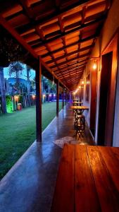 a covered porch with a table and chairs in a park at Pousada Paraíso Mineiro in Capitólio