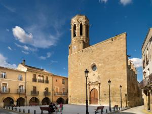 a large brick building with a clock tower at Apartament Perebep de Linyola in Linyola