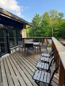 a wooden deck with chairs and a table on it at Blue Mountain Chalet in Blue Mountains