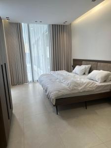 a bedroom with a large bed and a large window at شاليه بيرلا in Jeddah