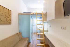 a small apartment with a couch and a ladder at Hygge Smart Stays in Lisbon