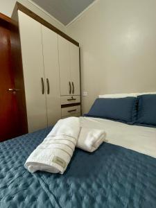 a bedroom with a bed with a towel on it at Quarto com area de descanso in Foz do Iguaçu