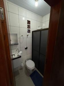 a small bathroom with a toilet and a sink at Quarto com area de descanso in Foz do Iguaçu +9 photos