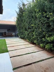 a garden with a stone walkway next to a bush at Quarto com area de descanso in Foz do Iguaçu
