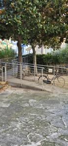 a bike parked next to a fence and trees at La Dépendance in Alassio