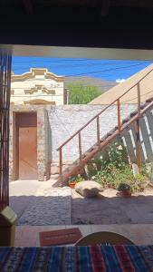 a wooden staircase leading to a building with a door at El MasSi in Tilcara