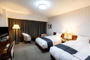 a hotel room with two beds and a desk at ホテルベルクラシック北見 in Kitami +40 photos