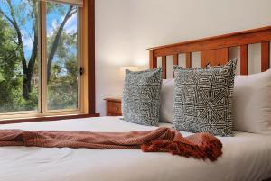 a bedroom with a bed with pillows and a window at Blue Moon in Beechworth