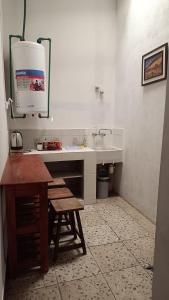 a kitchen with a sink and a counter with a stool at El MasSi in Tilcara +27 photos