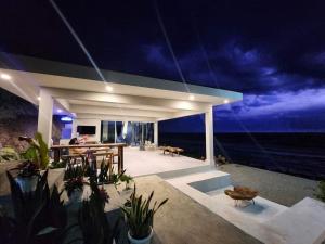 a house with a view of the ocean at night at Costa Moriah Manticao PH in Manticao
