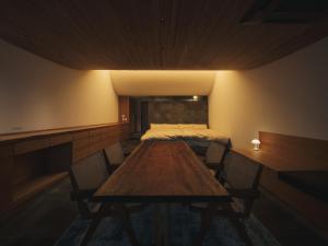 a room with a table and chairs and a bed at Good Fellows Resort in Kagoshima
