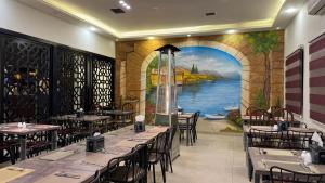 a restaurant with tables and a mural of a river at Ammania Hotel in Amman +22 photos