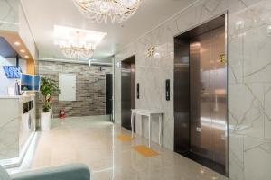 a lobby with a elevator and a chandelier at Browndot Hotel Godeok newtown in Pyeongtaek