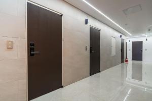 a row of elevator doors in a hallway at Browndot Hotel Godeok newtown in Pyeongtaek +38 photos