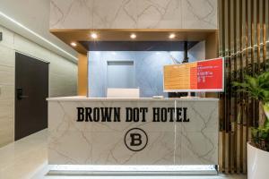 a brown dot hotel sign on a counter in a lobby at Browndot Hotel Godeok newtown in Pyeongtaek