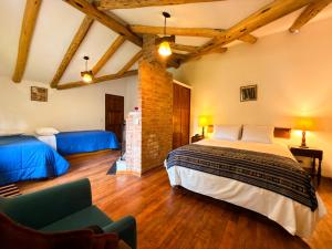 a bedroom with two beds and a chair in it at Hotel el Patio de Monterrey in Huaraz