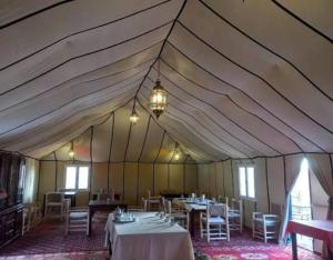 a large tent with tables and chairs in it at Best Classic Sahara Experiences in Merzouga