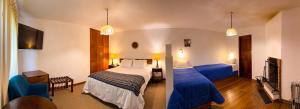 a hotel room with two beds and a television at Hotel el Patio de Monterrey in Huaraz