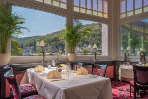 a dining room with a table and a large window at Romantik Jugendstilhotel Bellevue in Traben-Trarbach
